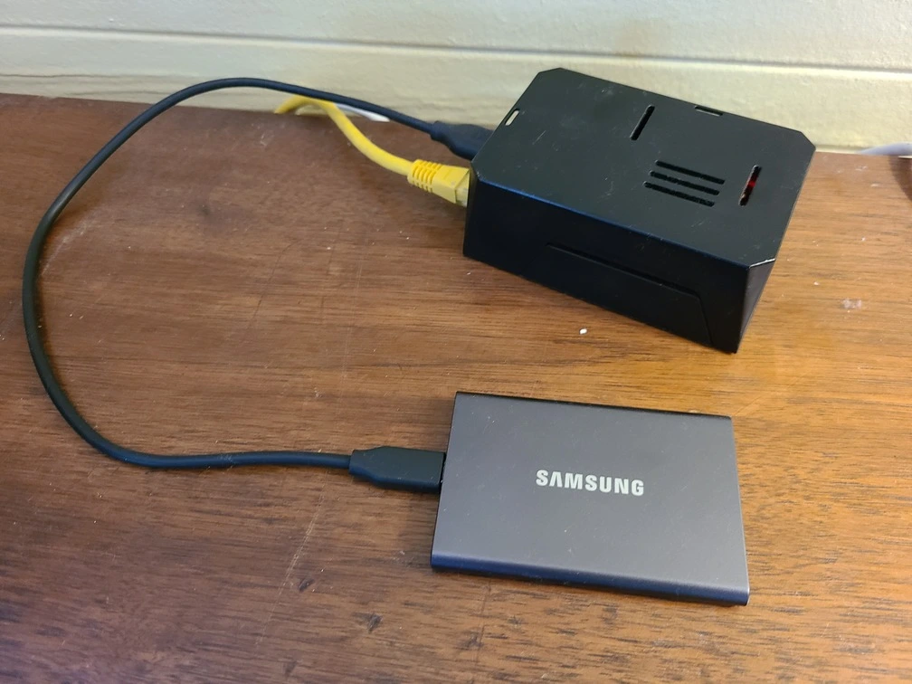 Figure 1: My humble Raspberry Pi and its hard drive. This dude currently tirelessly runs the excellent Adguard Home and downloads a backup of my data every night.